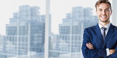 Businessman standing with arms crossed in office