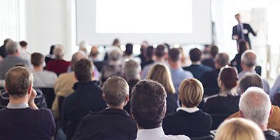 Speaker Giving a Talk at Business Meeting. Audience in the conference hall. Business and Entrepreneurship. Panoramic composition suitable for banners.